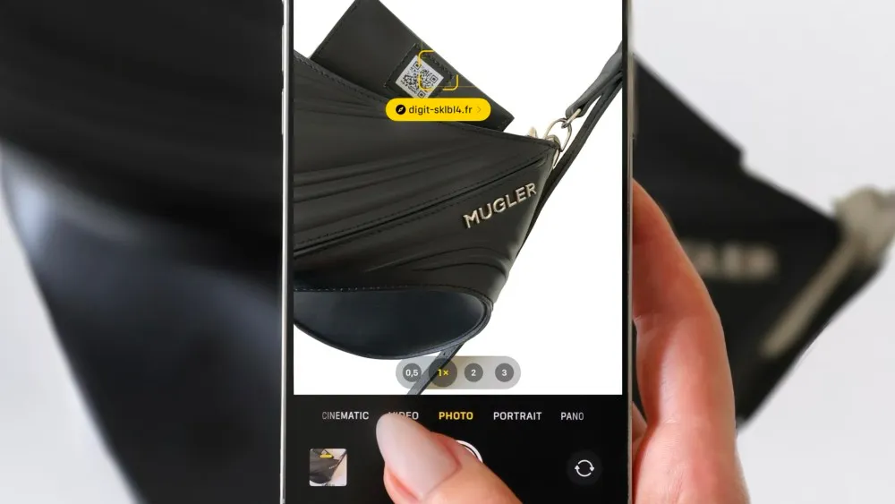 Un smartphone scanne le QR code d’un sac Mugler Spiral Curve