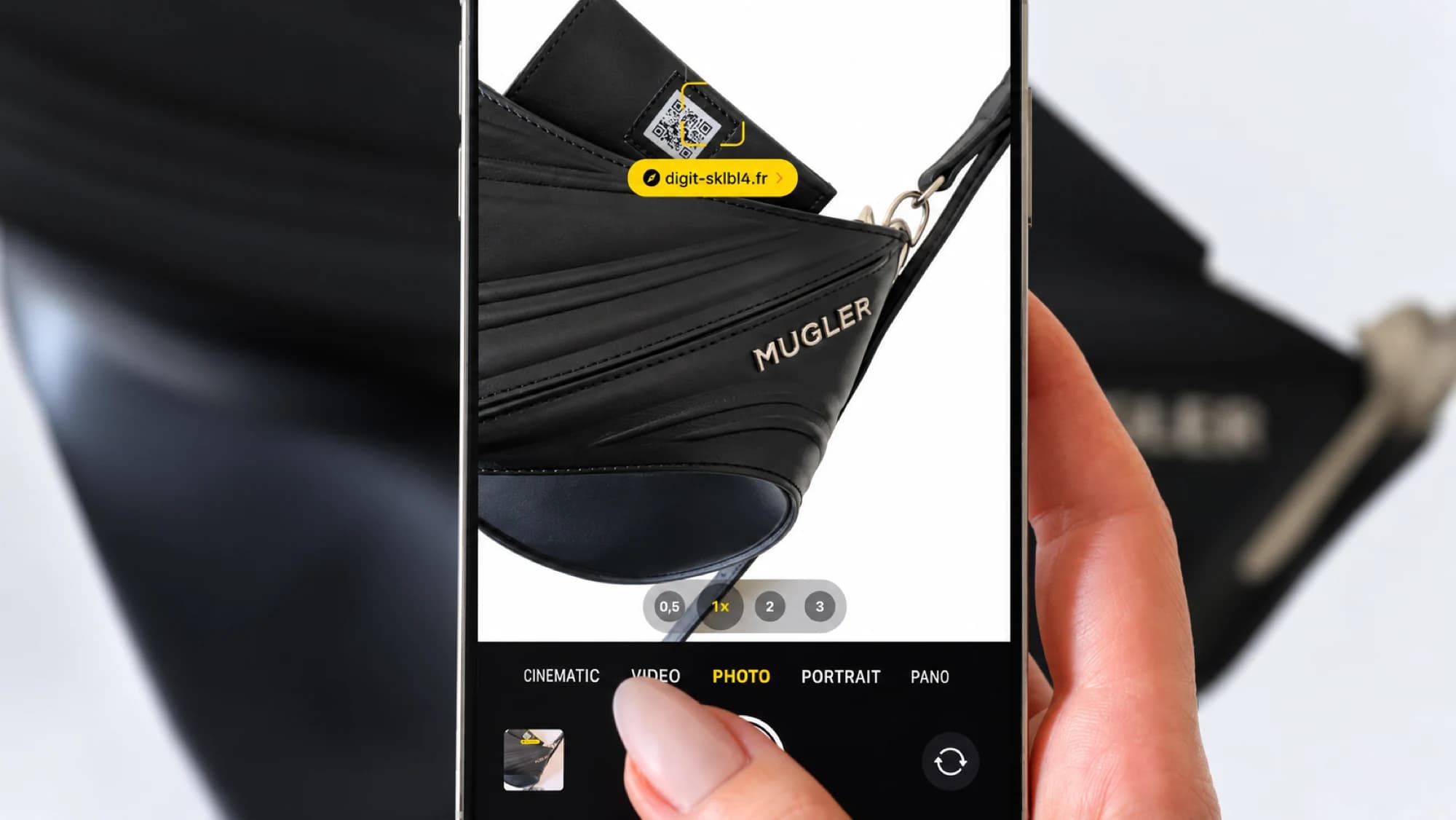 Un smartphone scanne le QR code d’un sac Mugler Spiral Curve