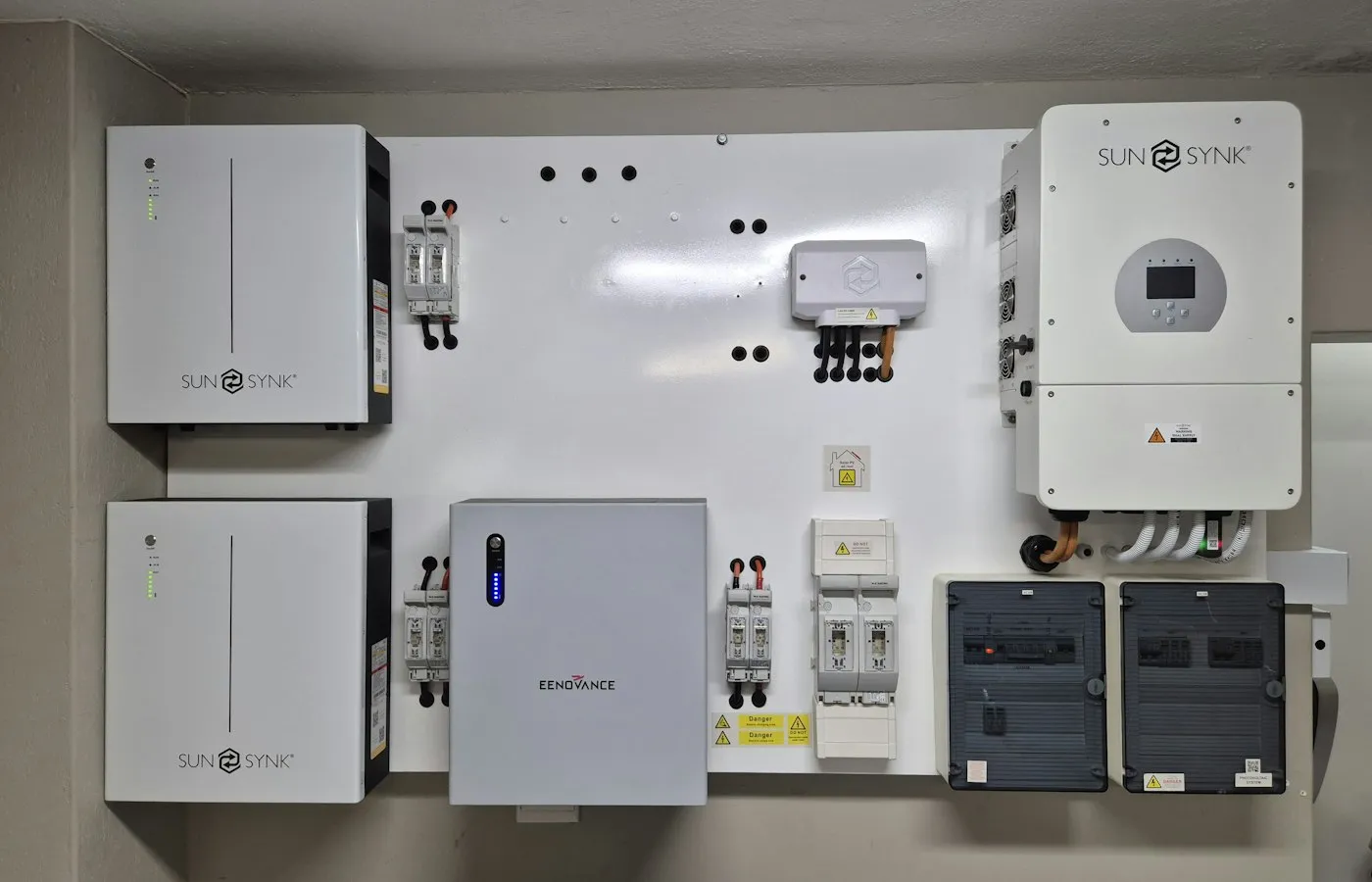 Wall-mounted energy storage installation with inverter and electrical enclosures